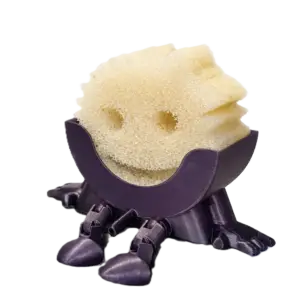 Scrub Daddy sponge sitting in a 3D printed holder with legs, designed to keep the sponge elevated and dry